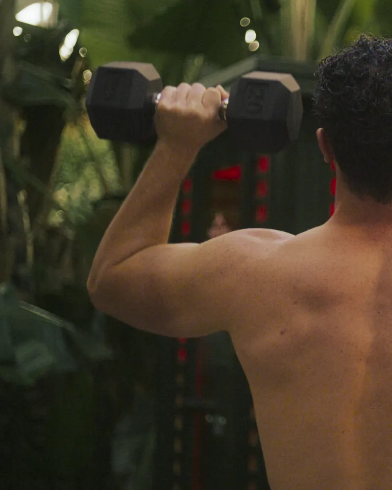 A man training with a dumbbell before a Peak sauna session